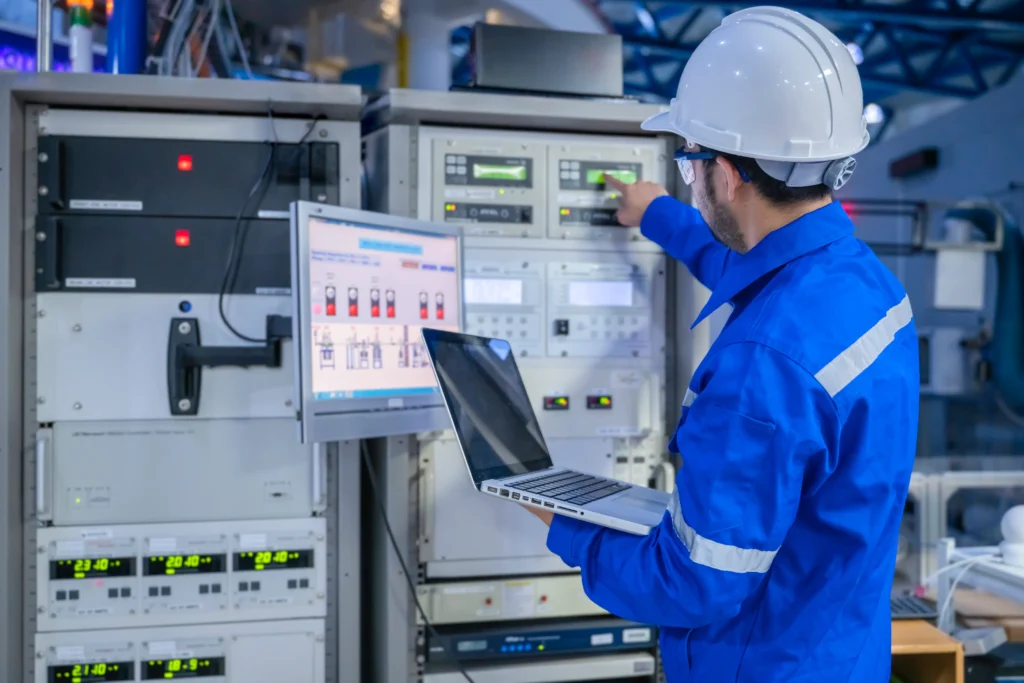 Technician inspecting electrical switchgear with a tablet