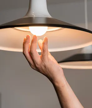 Hand installing an LED light bulb