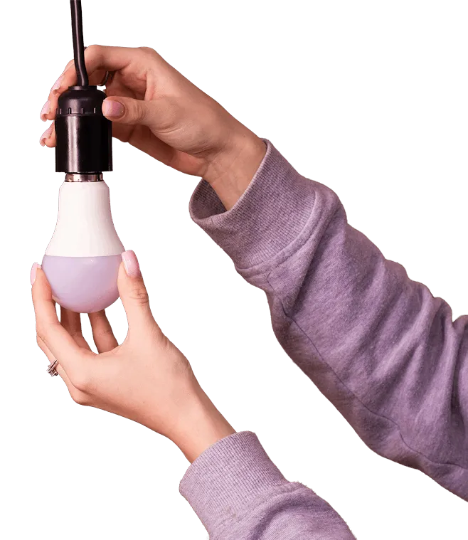Hands replacing a light bulb
